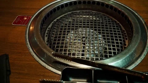 Yakiniku grill embedded into dining table at a Japanese BBQ restaraunt with 스톡 동영상 320465106
