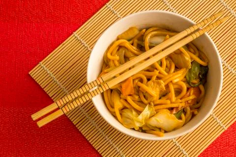 Yakisoba with beef, ticken and vegetables in a white bowl. Asian cuisine meal. Stock Photos