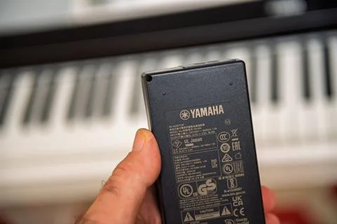 Yamaha AC Adapter Held with Keyboard in Background Stock Photos