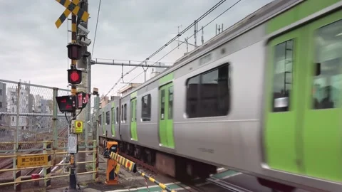 Yamanote line with a train passing at top speed over the last railroad crossing. Stock Footage 166303549