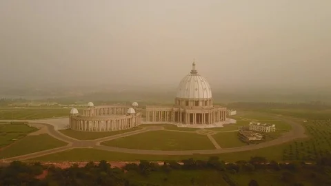 Yamoussoukro cathedral from above at dusk, harmattan light, zoom out Stock Footage 128745145