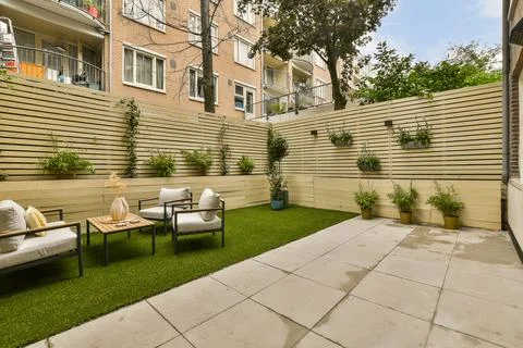 The yard has a seating area with chairs and plants Stock Photos
