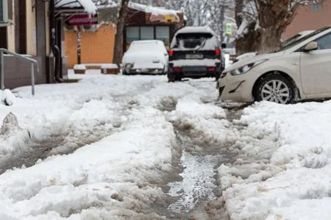 A yard in Krasnodar after a snowfall. Uncleaned sidewalks. Cars in the snow. Stock Photos
