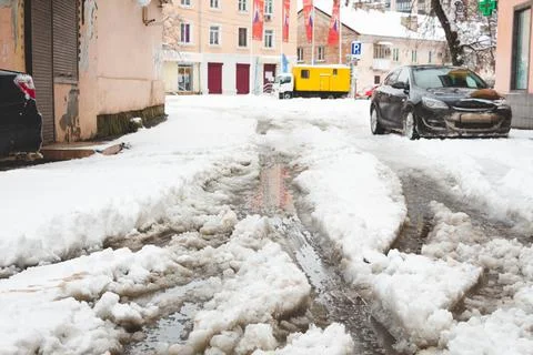 A yard in Krasnodar after a snowfall. Uncleaned sidewalks. Cars in the snow. Stock Photos