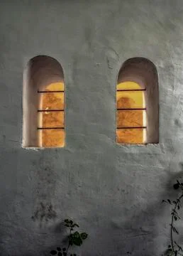A yard wall with two eye-windows. Stock Photos