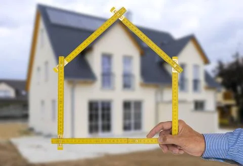 Yardstick folded in form of an house in hand of an agent yardstick folded ... Stock Photos