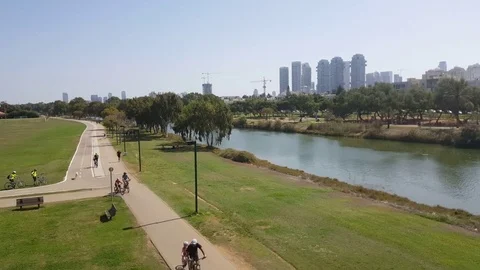 Yarkon River, people run and ride bikes in park, Akirov buildings, high angle Vídeos de archivo 80648908
