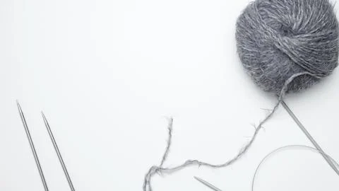 Yarn ball with assorted knitting needles arranged on table for knitting work Stock Photos