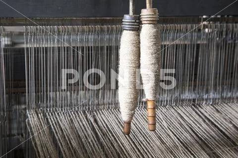 Yarn on bobbins on loom Stock Photos