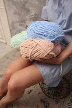 Yarn close-up in the hands of a young unrecognizable girl. A young woman in a Stock Photos