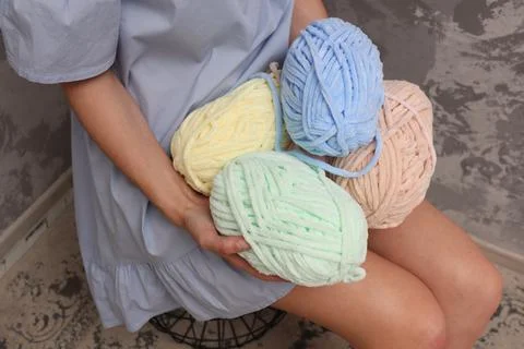 Yarn close-up in the hands of a young unrecognizable girl. A young woman in a Stock Photos