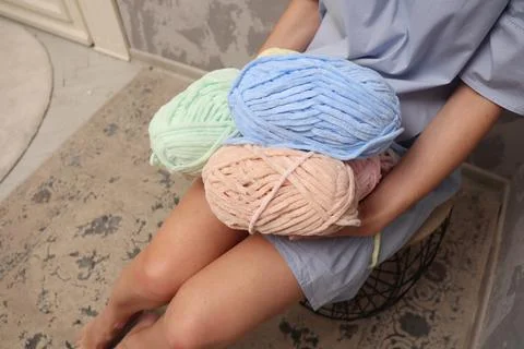 Yarn close-up in the hands of a young unrecognizable girl. A young woman in a Stock Photos
