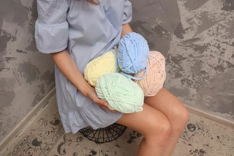 Yarn close-up in the hands of a young unrecognizable girl. A young woman in a Stock Photos