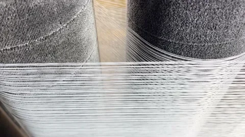 The yarns are unwound through the feed rollers on the knitting machine Stock Footage 238024550