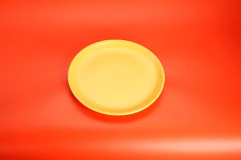 Yeallow empty  plate on red table Stock Photos