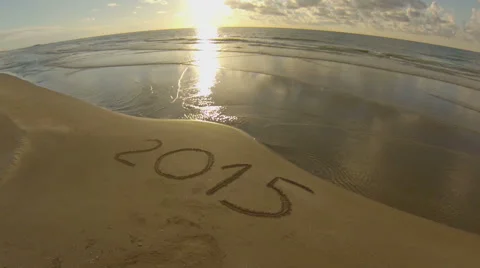 Year 2015 written on sand at sunset, aerial view Video stock 45370333