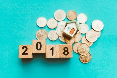 Year 2018 wooden block with stack coins and mini house Stock Photos