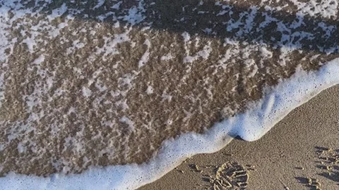 Year 2025 written in beach sand washed away by an ocean wave Stock Footage 346391260