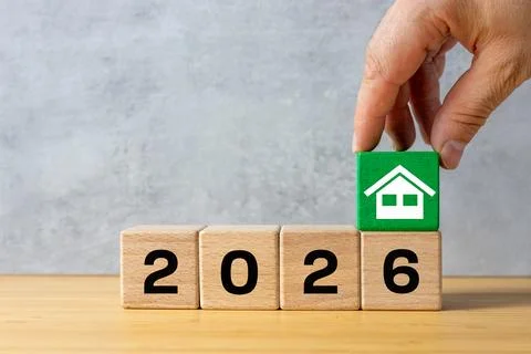 The year 2026. A hand forms a green house icon over the date 2026.  Stock Photos