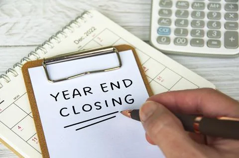 Year end closing written on notepad with December calendar and calculator bac Stock Photos