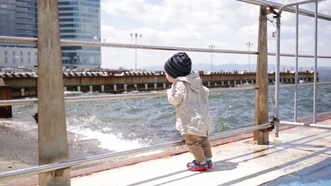  a year-old child looks at the waves. Stock Footage 90102007