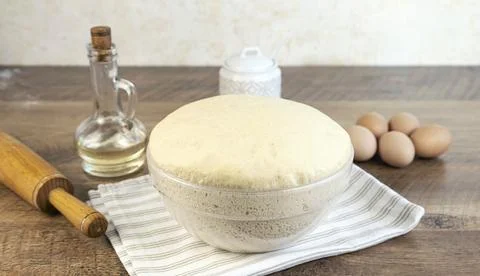 Yeast dough for baking bread on the kitchen table. 库存照片