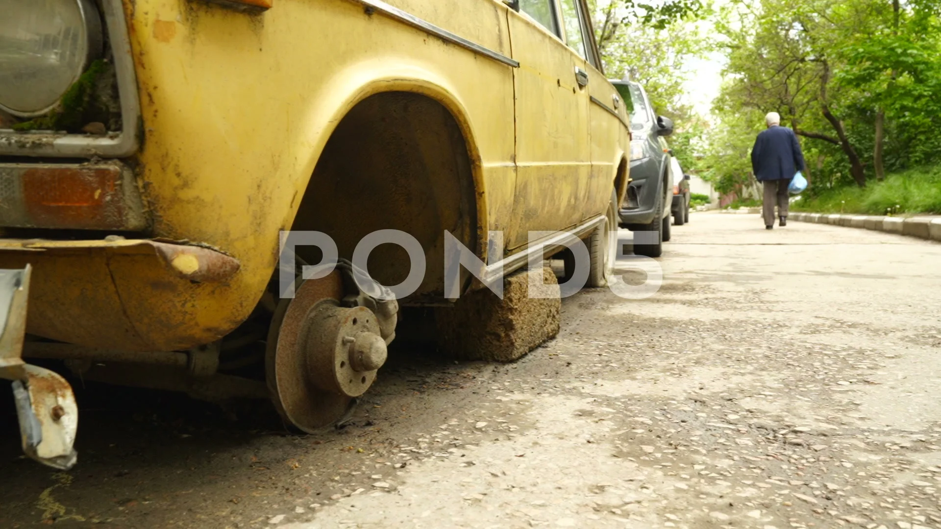 Yellow abandoned rusty car Lada VAZ-2106 sit in courtyard of apartment  building