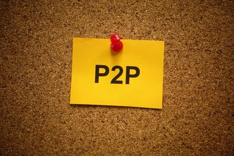 A yellow adhesive note with the acronym P2P on it pinned to a cork board. Stock Photos