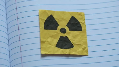 A yellow adhesive note with the radiation warning sign on it. Stock Footage 310137930