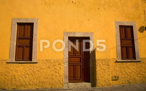 Yellow adobe house brown doors morelia mexico Stock Photos