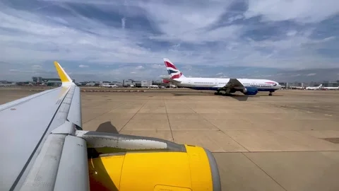 Yellow airplane wing and engine taxiing at london gatwick airport 库存影片 278854270