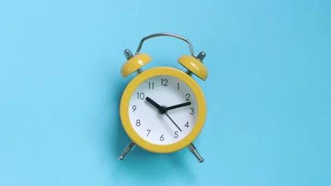 Yellow alarm clock on a blue background close-up, top view Stock Footage 139078069