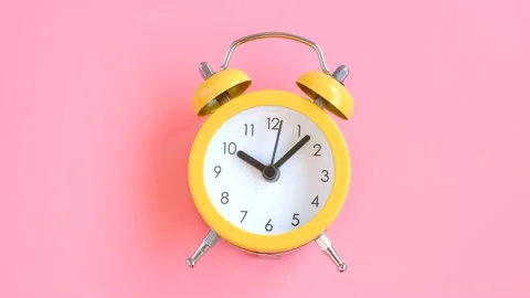 Yellow alarm clock on pink background close up. Stock Footage 229095123