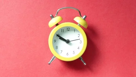 Yellow alarm clock on red background close-up Stock Footage 161690255