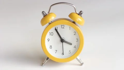 Yellow alarm clock on white background close-up Stock Footage 145499936