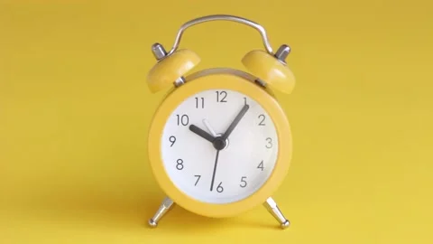 Yellow alarm clock on yellow background close-up Stock Footage 145463111