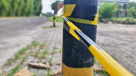 Yellow and Black Caution Tape on Bollard for Restricted Area Access Control Video stock 333507631