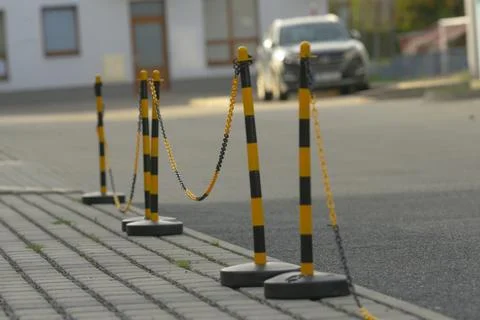 Yellow and black safety posts with chain mark temporary no parking zone Stock Photos