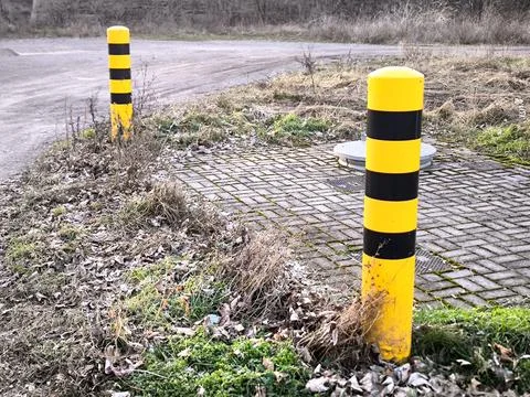 Yellow and black warning posts on the side of the road Foto stock