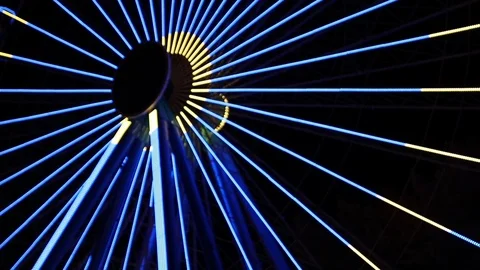 Yellow and blue light show on a ferris wheel at night Stock Footage 120527017