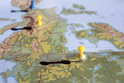 Yellow and blue pushpin showing the location of a destination point on a map Stock Photos