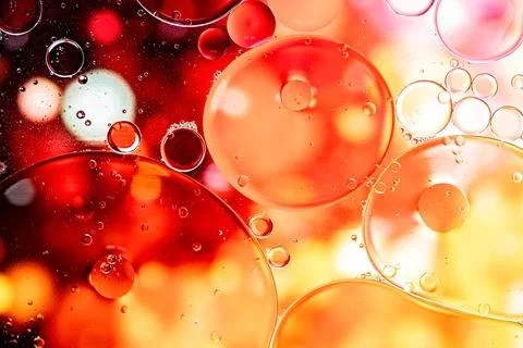 Yellow and orange abstract pattern made with oil bubbles and lights on water Stock Photos