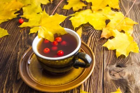 Yellow and orange fallen maple leaves on dark brown wood table background. Stock Photos