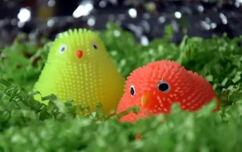 Yellow and orange plastic easter chicken figures in green nest. Happy Easte.. Stock Photos