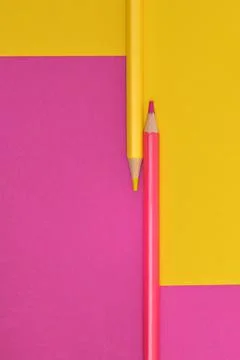 Yellow and pink crayons on the same paper background Stock Photos