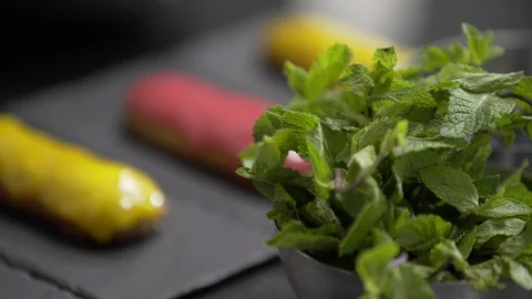 Yellow and pink glaze eclair on stone plates 스톡 동영상 95930917