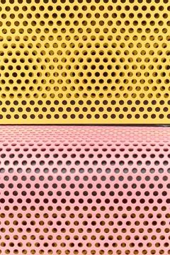 Yellow and pink perforated patterns separated by horizontal line 스톡 사진
