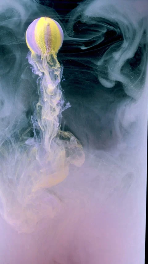 Yellow and purple painted sphere releasing pastel smoke flow over dark teal stud Stock Footage 340780565