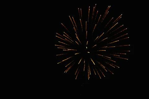 Yellow and red Firework growing in luminous sparks after the blow up Stock Photos