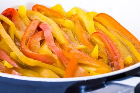 Yellow and red peppers while cooking Stock Photos